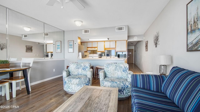 living area featuring visible vents, ceiling fan, and wood finished floors