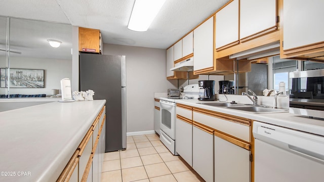 kitchen featuring light tile patterned floors, a sink, stainless steel appliances, light countertops, and under cabinet range hood