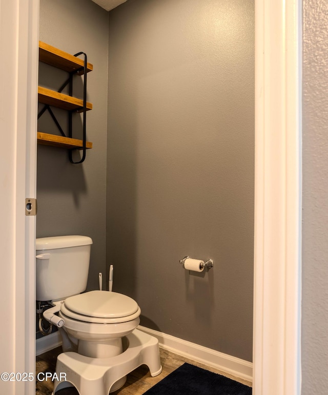 bathroom with baseboards and toilet