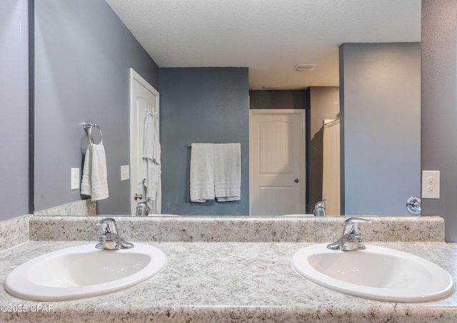 full bathroom with a textured ceiling and vanity