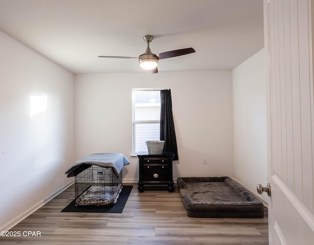 bedroom featuring a ceiling fan, wood finished floors, and baseboards