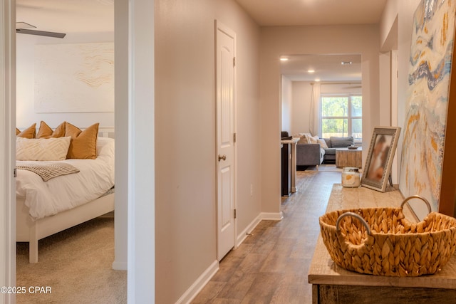 corridor with baseboards and wood finished floors