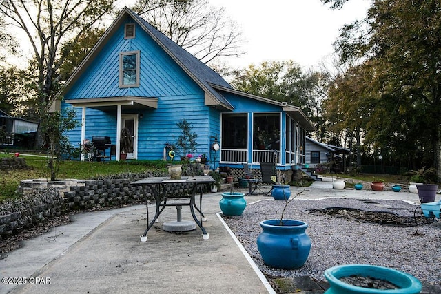 rear view of property with a patio area and a sunroom