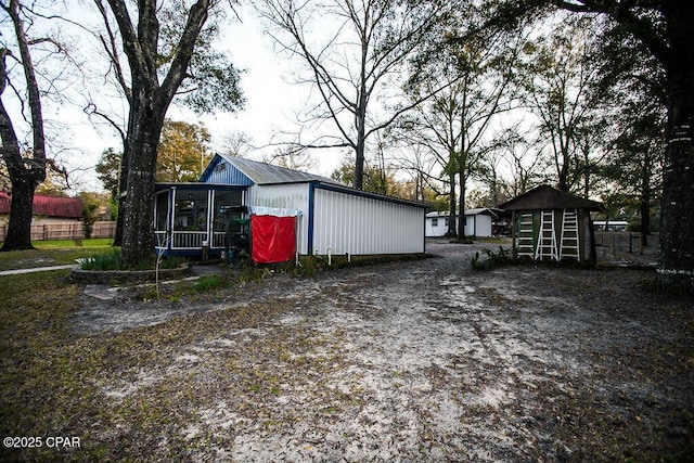 view of outdoor structure featuring an outbuilding and a sunroom