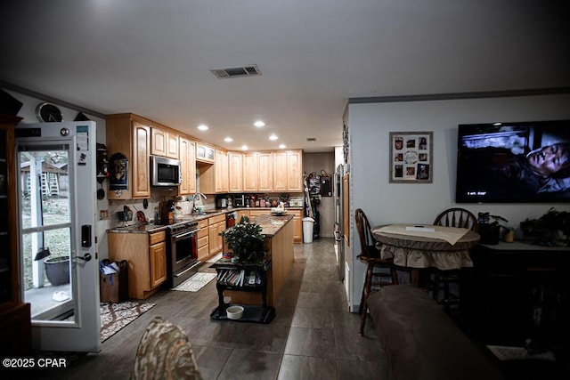 kitchen with visible vents, recessed lighting, a sink, appliances with stainless steel finishes, and a center island