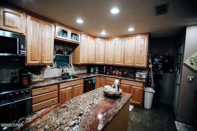 kitchen featuring visible vents, black appliances, dark stone counters, and a sink