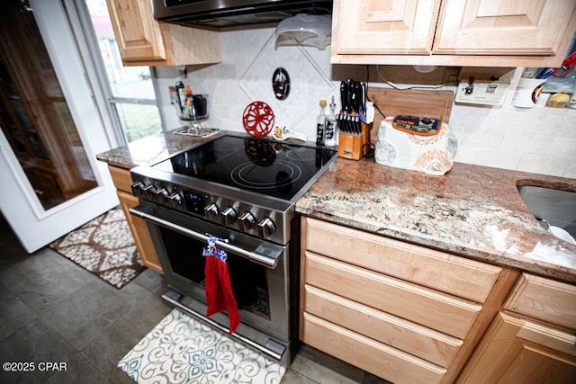 kitchen with light brown cabinets, decorative backsplash, stainless steel range with electric stovetop, and light stone countertops