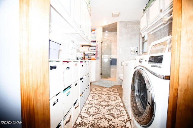 laundry area with washer and dryer and tile walls