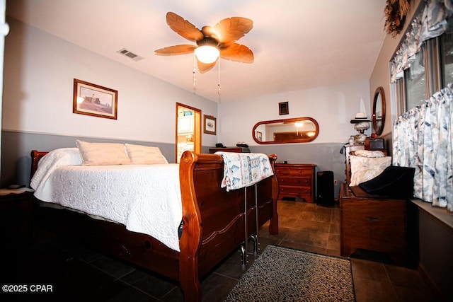 tiled bedroom with a ceiling fan and visible vents