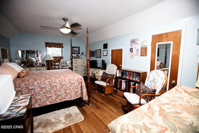 bedroom featuring a ceiling fan, lofted ceiling, wood finished floors, and a textured ceiling