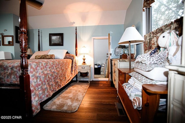 bedroom with vaulted ceiling and hardwood / wood-style floors