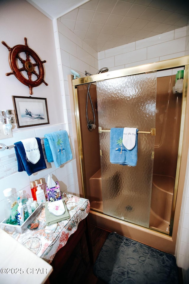 bathroom featuring decorative backsplash, a stall shower, and tile walls