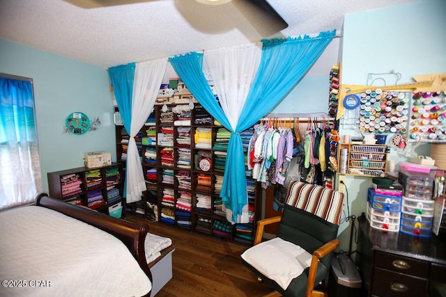 bedroom featuring a ceiling fan, wood finished floors, and a textured ceiling