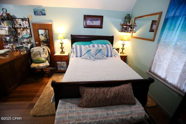 bedroom with vaulted ceiling and wood finished floors