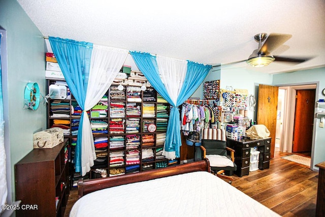 bedroom featuring a ceiling fan, wood finished floors, and a textured ceiling