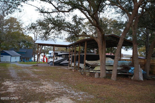 exterior space featuring a carport and dirt driveway