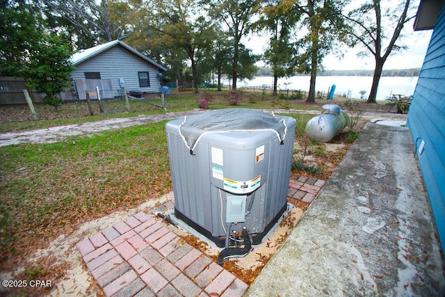 exterior details featuring heating fuel, cooling unit, and fence