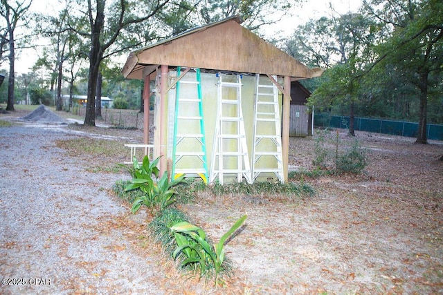 view of outdoor structure featuring an outbuilding and fence