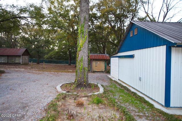 view of yard featuring fence, an outdoor structure, and a shed