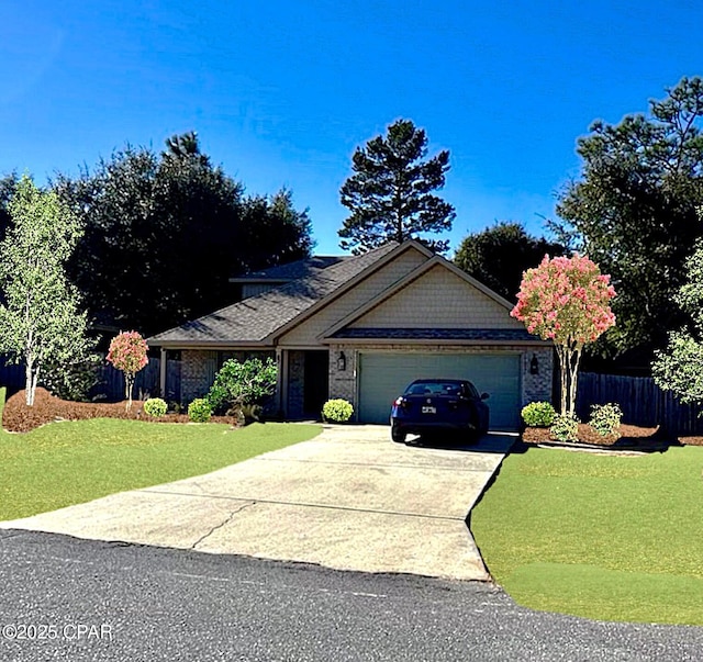 view of front of home featuring a garage, driveway, a front lawn, and fence