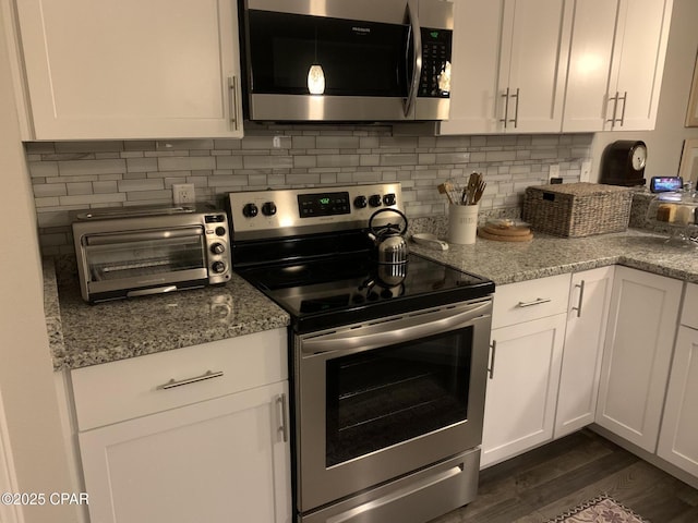 kitchen featuring decorative backsplash, white cabinetry, and appliances with stainless steel finishes