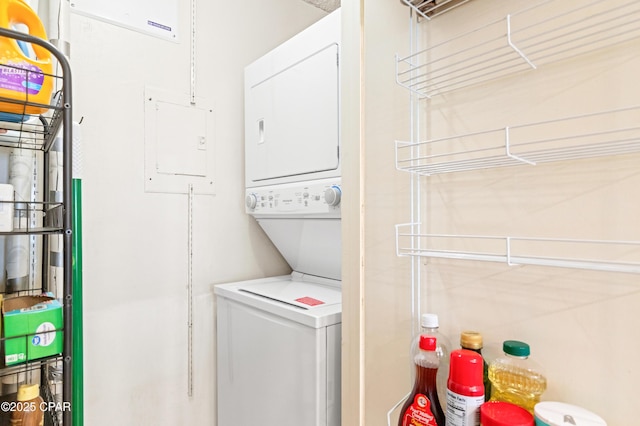 clothes washing area featuring electric panel, laundry area, and stacked washer and dryer