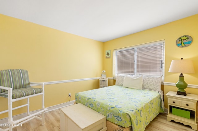 bedroom with baseboards and wood finished floors