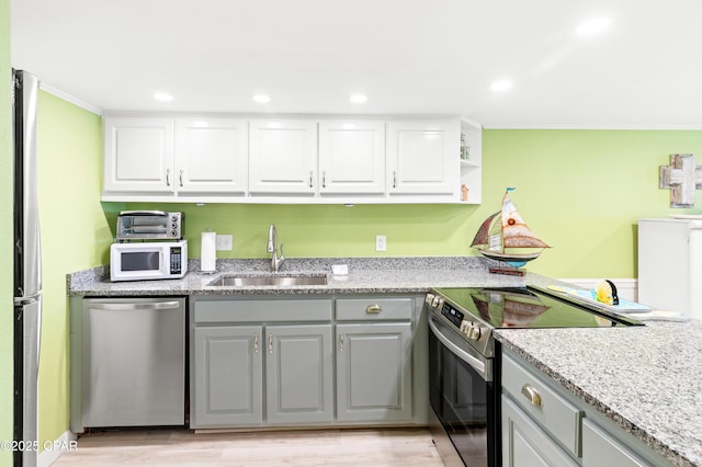 kitchen with a sink, appliances with stainless steel finishes, gray cabinets, and white cabinetry