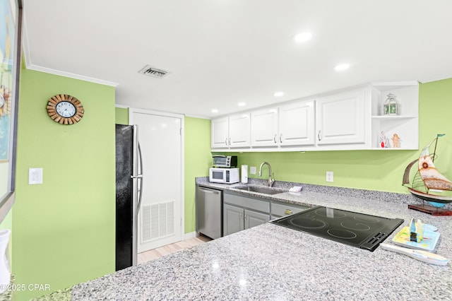 kitchen featuring light stone countertops, visible vents, a sink, stainless steel appliances, and white cabinetry