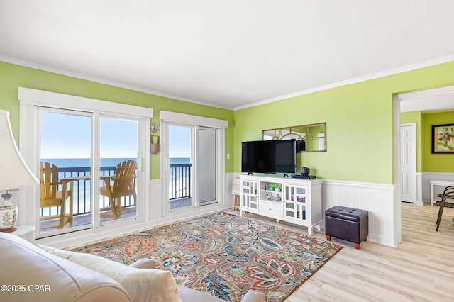 living room with wainscoting, crown molding, and wood finished floors