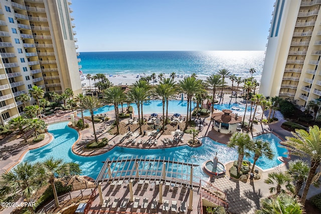 view of swimming pool with a beach view and a water view