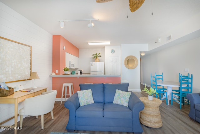 living area featuring visible vents, track lighting, wood finished floors, and a ceiling fan