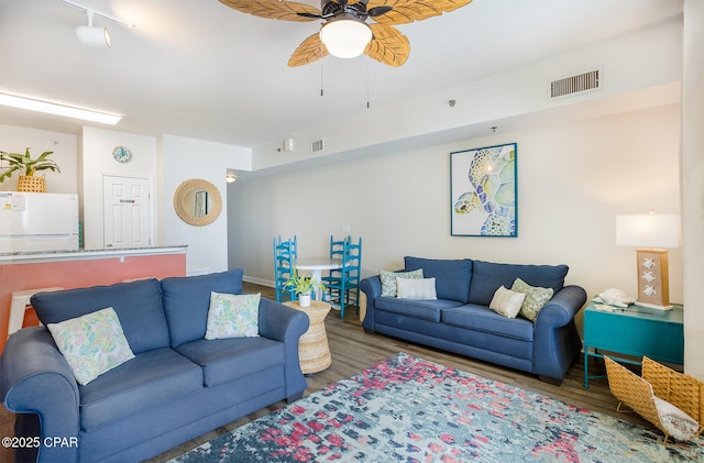 living area featuring visible vents, ceiling fan, and wood finished floors