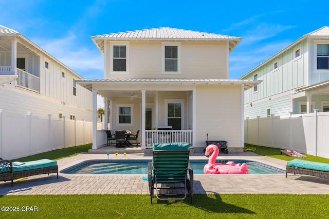 back of house featuring a ceiling fan, a patio, a fenced backyard, metal roof, and a fenced in pool