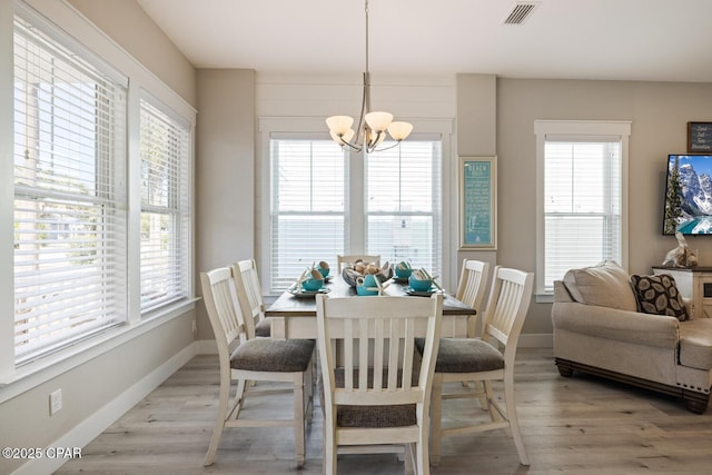 dining space with light wood-type flooring, visible vents, plenty of natural light, and an inviting chandelier