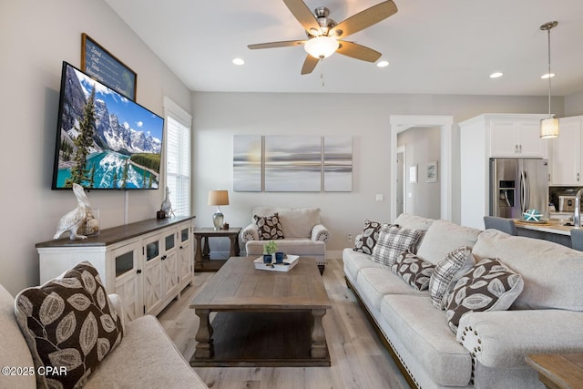 living room with recessed lighting, light wood-type flooring, and a ceiling fan