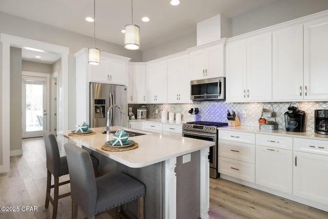 kitchen featuring white cabinets, tasteful backsplash, appliances with stainless steel finishes, and a sink