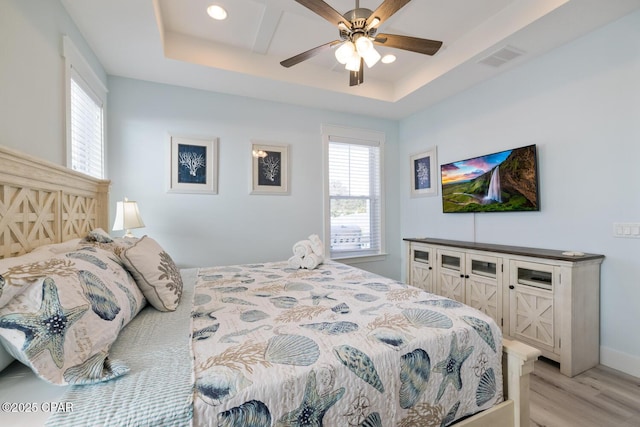 227 Sands St, Panama City Beach, FL 32413 - bedroom featuring a tray ceiling, light wood-style floors, recessed lighting, and a ceiling fan