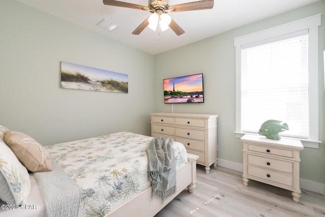 bedroom featuring visible vents, light wood-style flooring, a ceiling fan, and baseboards