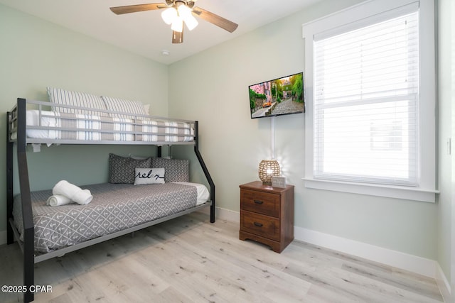 bedroom with ceiling fan, baseboards, and wood finished floors