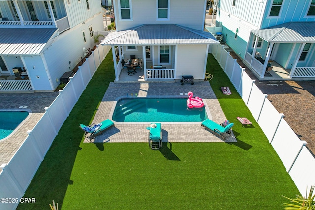 view of pool featuring a yard, a patio, and a fenced backyard