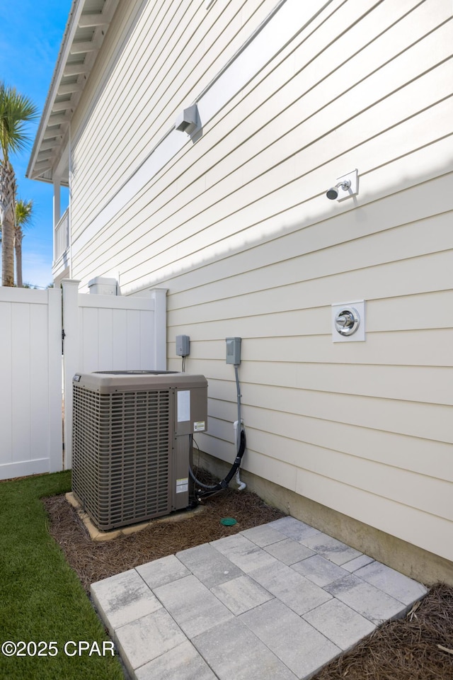 exterior space featuring central AC unit and fence