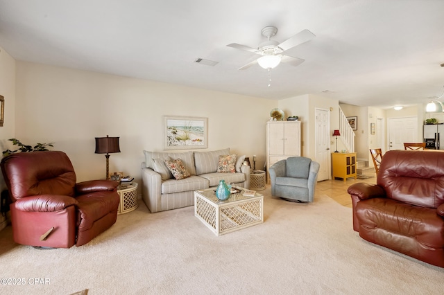 living room featuring visible vents, carpet, and a ceiling fan