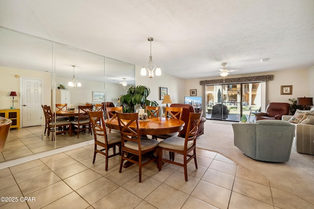 dining area featuring light tile patterned flooring and ceiling fan with notable chandelier