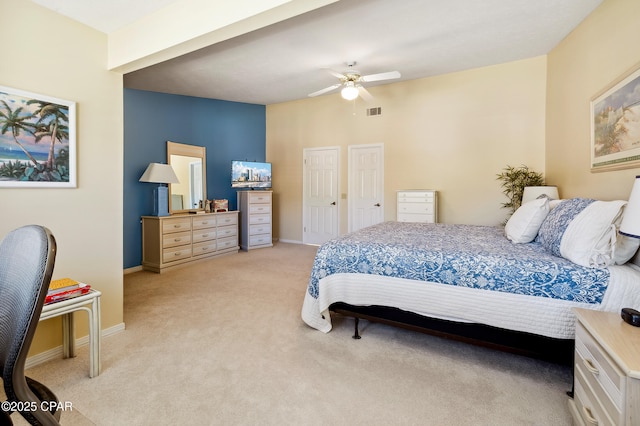 bedroom with visible vents, light carpet, baseboards, and a ceiling fan