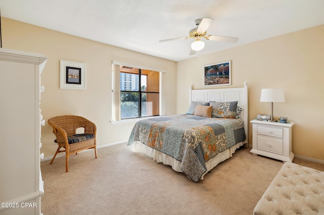 bedroom with ceiling fan, baseboards, and light carpet