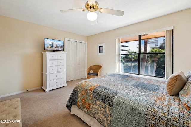 bedroom with light carpet, a closet, baseboards, and a ceiling fan