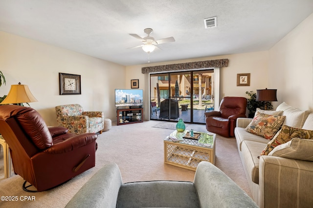 carpeted living room featuring visible vents, a textured ceiling, and ceiling fan