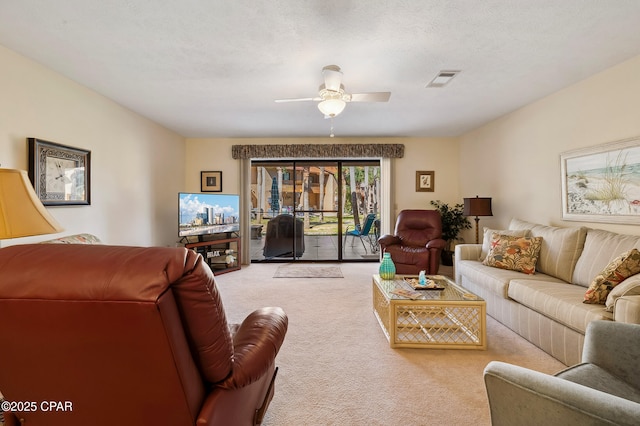 carpeted living room with visible vents, a textured ceiling, and ceiling fan