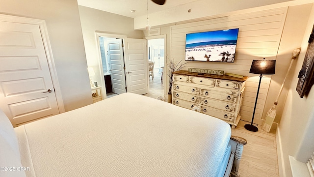 bedroom with ensuite bath and wooden walls